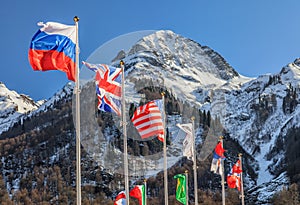 Russia, Great Britain, USA and other national flags flutter on mountain peak background