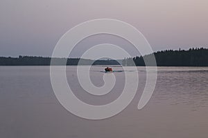 Russia, Karelia. White nights. Lake Muezero. Tourists on an inflatable boat floating on the lake