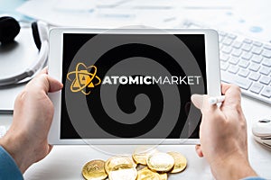 Russia Moscow 05.05.2021.Man holding tablet with logo of NFT marketplace Atomic market. Non fungible tokens for cryptocurrency WAX