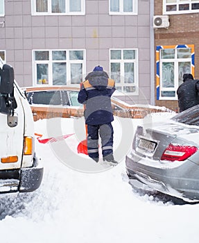 Russia Moscow 13.02.2021 Street cleaners, men clean snow from road, sidewalk with large shovels. City winter weather