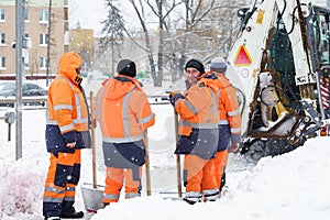 Russia Moscow 13.02.2021 Street cleaners,men clean snow from road,sidewalk with large shovels.Tractor,snow removal