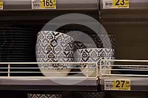 Plates, salad bowls on the shelf in the supermarket