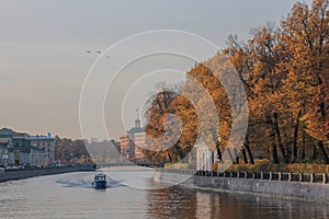 Russia, St. Petersburg, stunning autumn red trees, the kater river, birds flying in the sky. Lyrical exciting lighting, gentle day photo