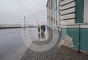 Russia, St. Petersburg in the summer in the rain. A rainy gray cloudy city. View of the sights. University Embankment. People unde