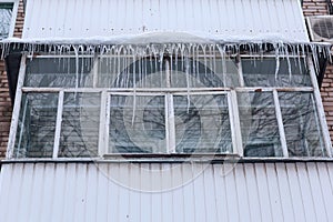 Russia. Terrible huge icicles formed on the balcony of a multi-storey building