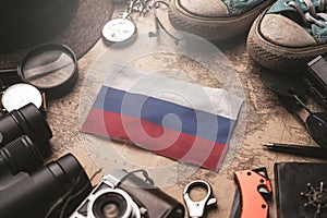 Russia Between Traveler`s Accessories on Old Vintage Map. Tourist Destination Concept