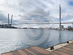 Russia, Vladivostok. Golden bridge - cable-stayed bridge across Golden horn Bay and fragment of  Tsarevich embankment in autumn in