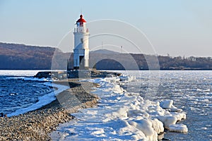 Russia. Vladivostok. The lighthouse of Egersheld1876 year built Tokarevskaya koshka in winter evening in Amur bay