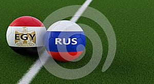 Russia vs. Egypt Soccer Match - Soccer balls in Egypts and Russias national colors on a soccer field.