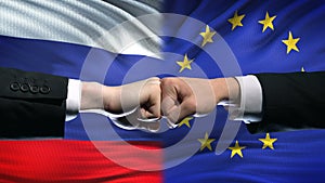 Russia vs EU conflict, international relations crisis, fists on flag background