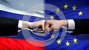 Russia vs EU conflict, international relations crisis, fists on flag background