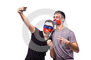 Futbaloví fanúšikovia Rusko vs Slovensko si robia selfie fotografiu s telefónom na bielom pozadí