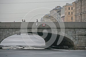 Russia, Winter St. Petersburg, Snow-covered river, soft winter daylight. Beautiful massive stone bridge close-up. Winter Russia.