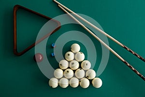 Russian billiard balls, cue, triangle, chalk on a table.