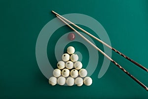 Russian billiard balls, cue, triangle, chalk on a table.