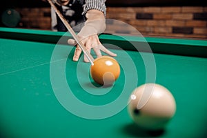 Russian billiards, man plays and beats cue on white ball