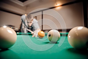 Russian billiards, man plays and beats cue on white ball