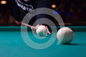 Russian billiards player aims to shoot white ball with cue