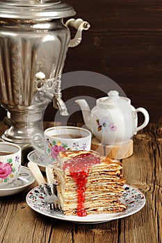 Russian bliny with raspberry jam, vintage samovar and teaware