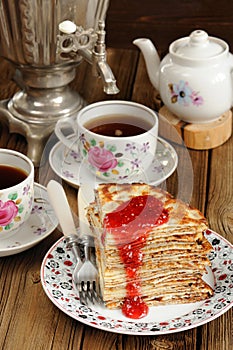 Russian bliny with raspberry jam, vintage samovar and teaware