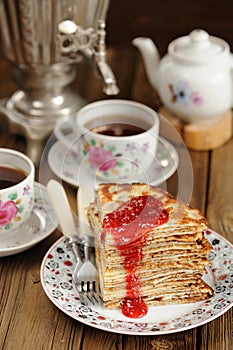 Russian bliny with raspberry jam, vintage samovar and teaware