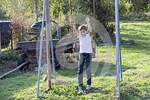 Russian boy rides on a swing in the summer