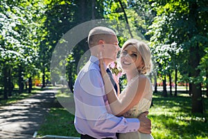 Russian bride and groom together in green city park