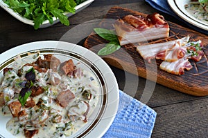 Russian cuisine: closeup beef meat stewed with vegetables in ceramic pot on wooden background
