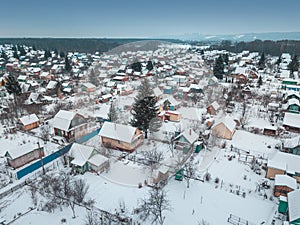 Russian dacha village near the lake and forest in winter, aerial view