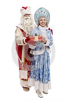 Russian Ded Moroz and Snegurochka in beautiful costumes with a gift. Celebrating New Year and Christmas. Full height. Isolated on photo