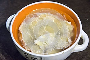 Russian dumplings in broth in an orange plate