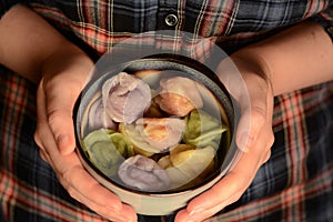 Russian dumplings with meat natural colored in hands closeup. Russian traditional food pelmeni