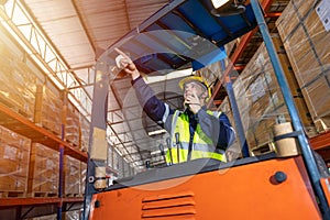 Russian European male staff worker working control loading operate folk lift in warehouse inventory factory