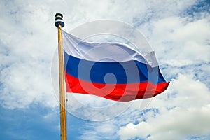 Russian flag close-up against a cloudy sky background