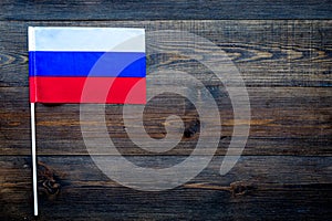 Russian flag concept. Small flag on dark wooden background top view copy space