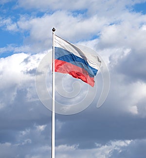 Russian flag on the flagpole waving on cloudy sky