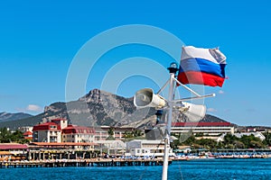 Russian flag and loudspeakers against the background of the sea and sky
