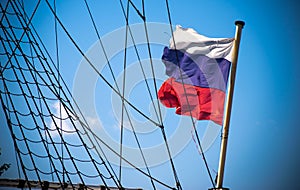 Russian flag near shipboard ropes