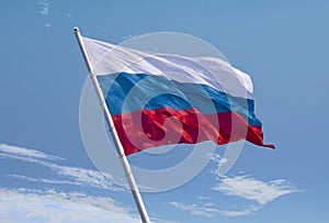 Russian flag waving in the wind over blue sky
