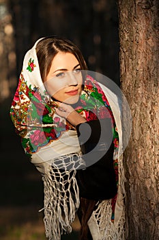 Russian girl in headscarves near the tree in the forest