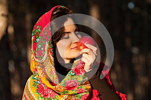 Russian girl in national headscarves with apple