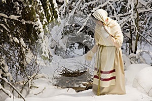 Russian girl with a sled in the winter woods