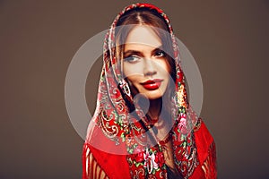 Russian girl style. Fashion woman portrait with traditional red headscarf. Beauty girl model with red lips makeup  on