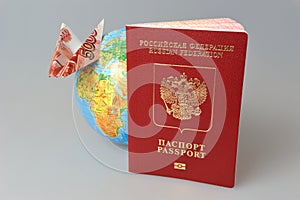 Russian International passport, globe and origami plane made fro