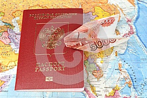 Russian international passport with origami plane made from money on the map