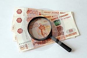 Russian money and magnifying glass