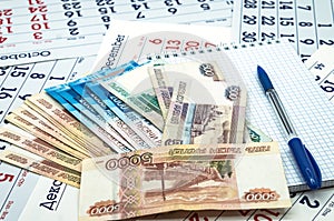 Russian money and a Notepad, a blue pen and Russian banknotes, a clean sheet and a blue pen
