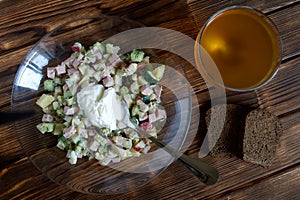 Russian national dish - okroshka with sour cream. Cold soup with meat, vegetables and kvass. Separate cooking. Two slices of black