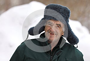 Russian old man in winter hat smiles