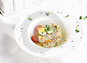 Russian Olivier salad with meat, quail eggs and cherry tomatoes